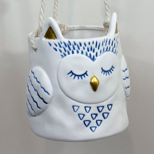 Close up of hanging owl planter, with with blue details and gold beak