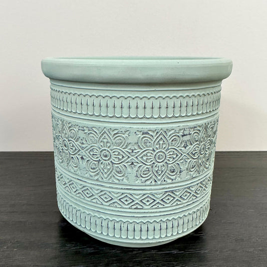 close up of a decorative mint green 5" pot with floral pattern